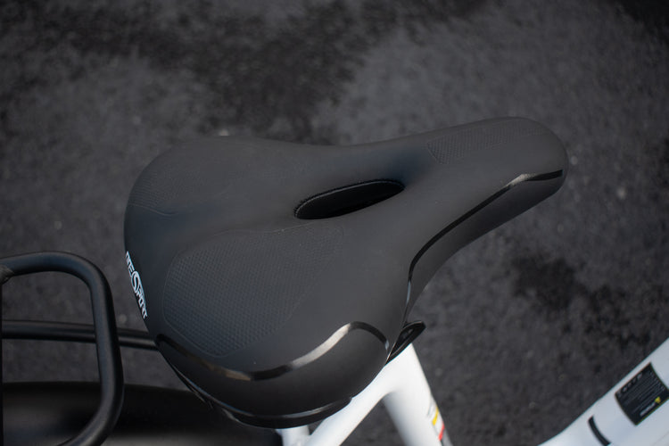 Close-up of the electric bike saddle showing ergonomic design and shock-absorbing seat post